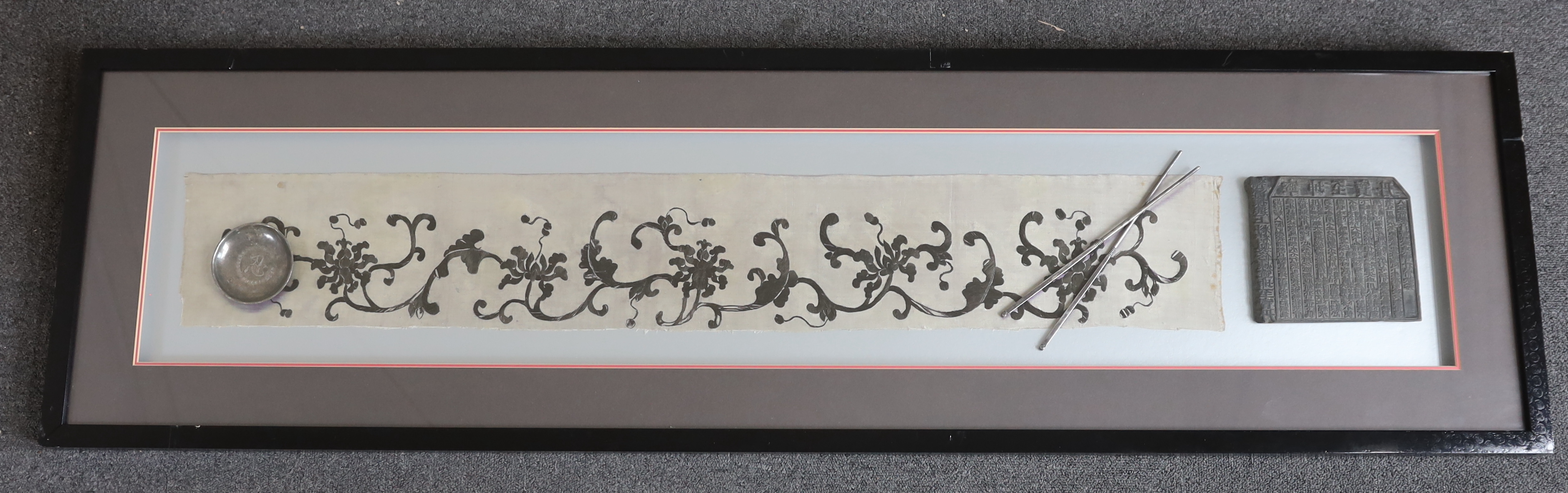 A late 19th century Chinese black and cream silk embroidery, mounted together with an inscribed calligraphic stone, a pair of white metal chop sticks and a similar dish, embroidery: 5.5cm wide, 105cm long